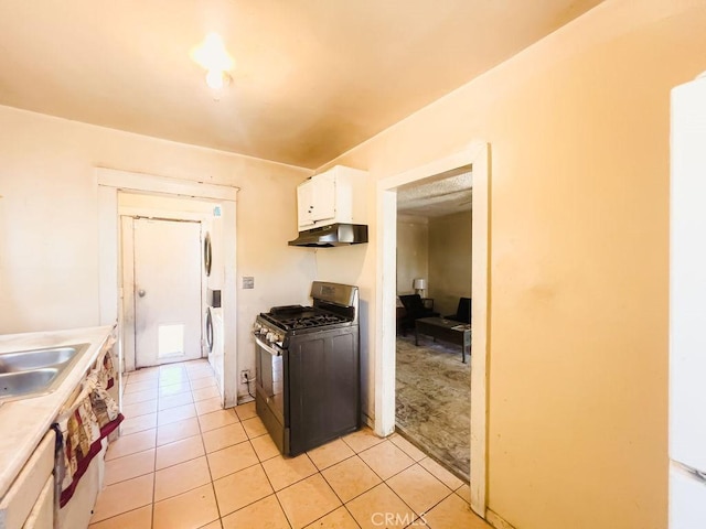 kitchen featuring white cabinets, sink, light tile patterned flooring, and black range with gas cooktop