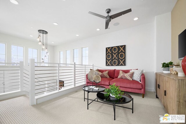 carpeted living room featuring a wealth of natural light and ceiling fan