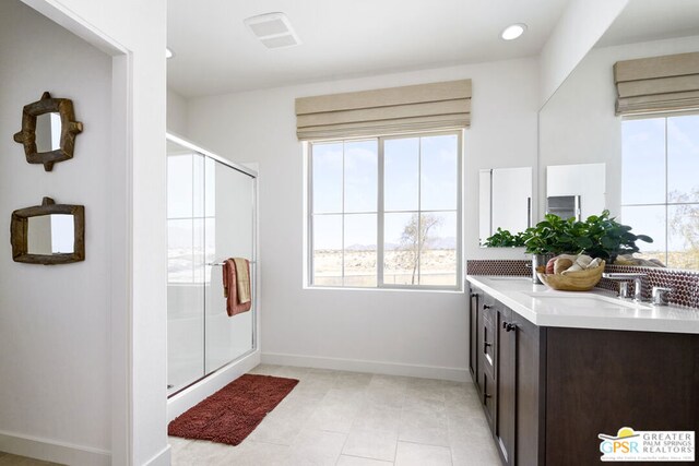 bathroom with an enclosed shower, vanity, tile patterned floors, and a wealth of natural light