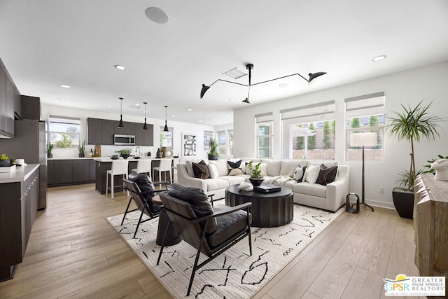 living room with a chandelier and light hardwood / wood-style flooring