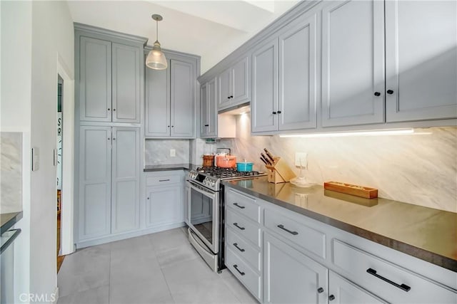 kitchen featuring pendant lighting, light tile patterned floors, tasteful backsplash, and stainless steel range with gas cooktop