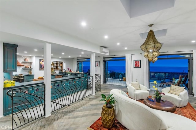 living area featuring light wood-style flooring, a wall unit AC, and recessed lighting