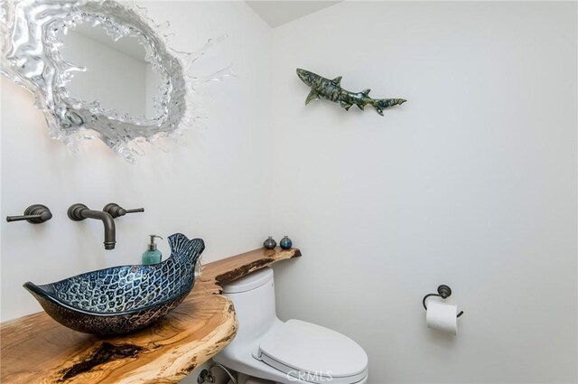 half bath featuring a sink and toilet