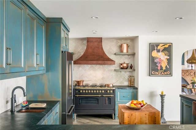 kitchen with hardwood / wood-style floors, premium range hood, sink, tasteful backsplash, and stainless steel appliances