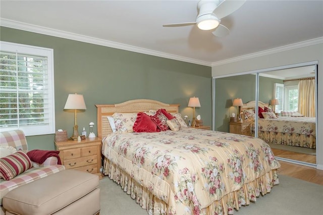 bedroom featuring a closet, ceiling fan, crown molding, and light colored carpet