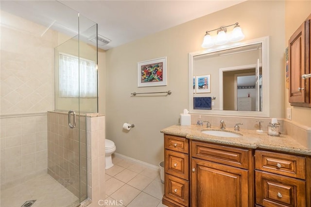 bathroom featuring toilet, vanity, tile patterned floors, and an enclosed shower