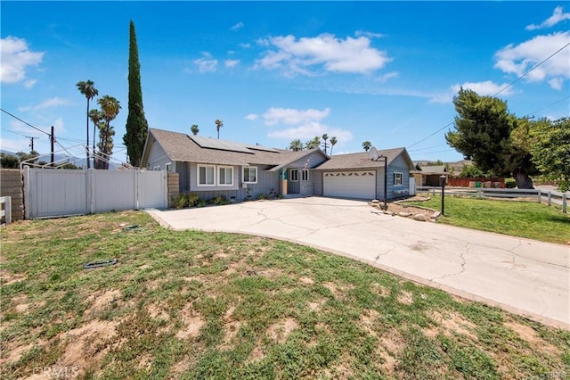 ranch-style house featuring a garage, a front lawn, and solar panels