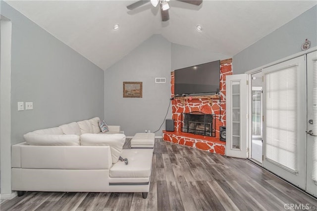 living room with a wealth of natural light, lofted ceiling, wood-type flooring, a fireplace, and ceiling fan