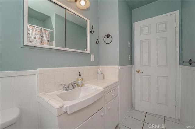 bathroom with toilet, vanity, and tile patterned floors