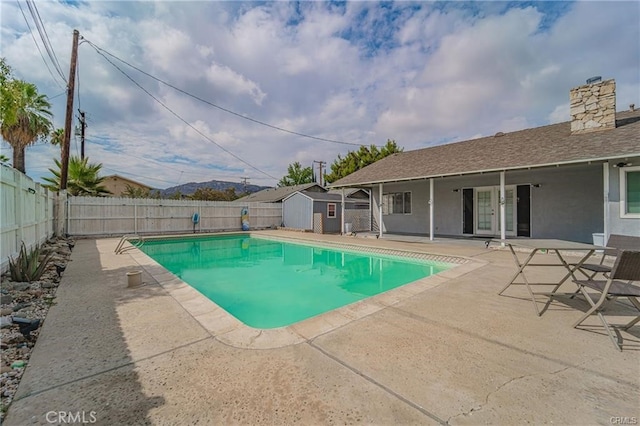 view of pool with a patio area and a storage shed