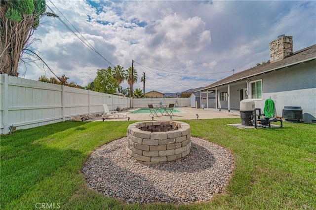 view of yard with a patio area, an outdoor fire pit, and central air condition unit