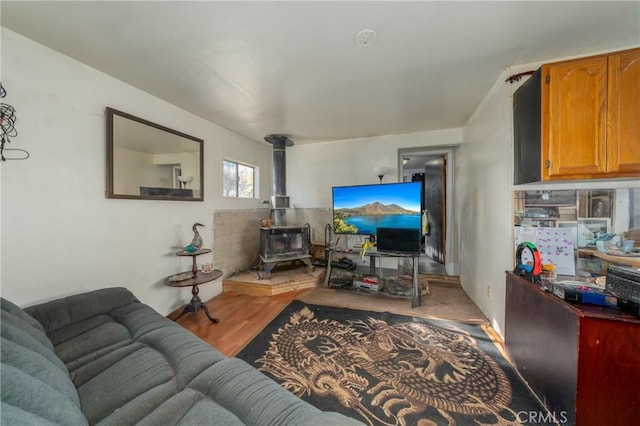 living room with light hardwood / wood-style floors and a wood stove