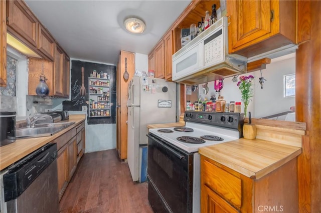 kitchen featuring white appliances, sink, and dark wood-type flooring