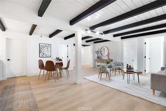 dining space featuring beam ceiling and light wood-type flooring