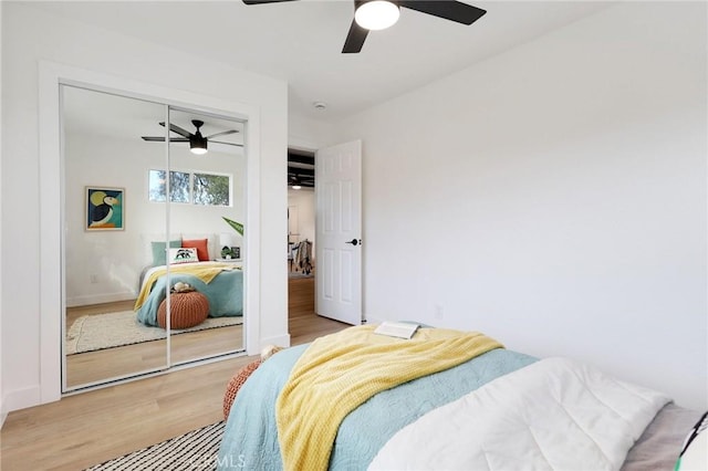 bedroom with hardwood / wood-style floors, a closet, and ceiling fan