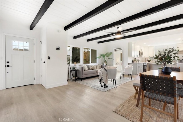 living room with beam ceiling, ceiling fan, and light wood-type flooring