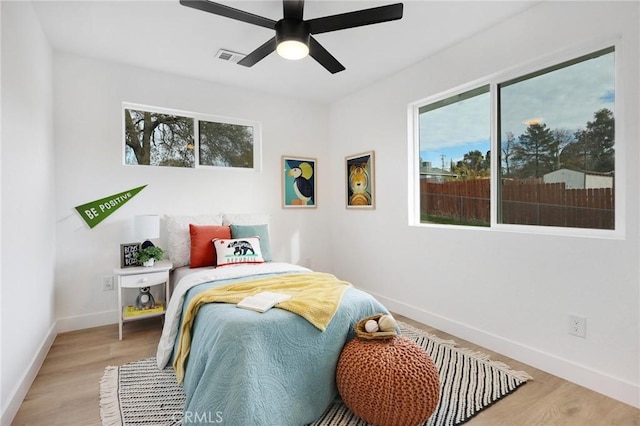 bedroom featuring multiple windows, ceiling fan, and hardwood / wood-style floors