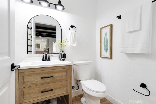 bathroom with hardwood / wood-style floors, vanity, and toilet