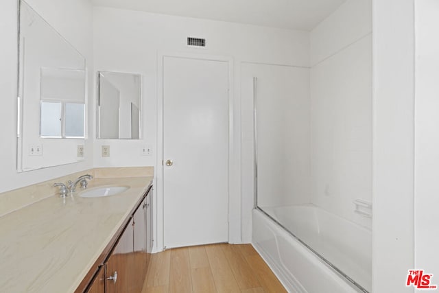 bathroom featuring shower / tub combination, hardwood / wood-style floors, and vanity