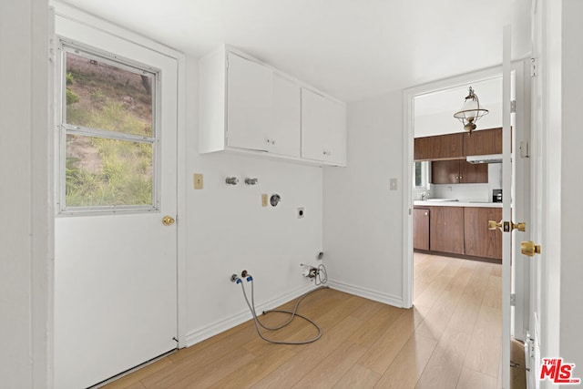 laundry room featuring cabinets, washer hookup, light wood-type flooring, electric dryer hookup, and hookup for a gas dryer