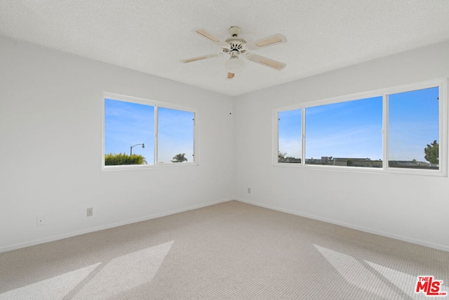 spare room with carpet flooring, plenty of natural light, and ceiling fan