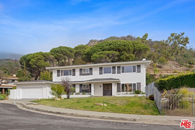 view of front of property with a front yard and a garage