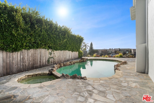 view of swimming pool featuring an in ground hot tub