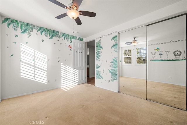 unfurnished bedroom featuring ceiling fan, a closet, and light colored carpet