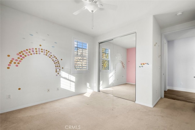 unfurnished bedroom with ceiling fan, a closet, and light carpet