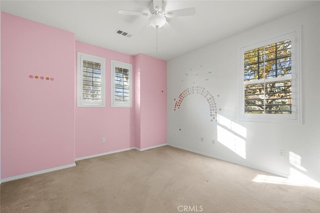 empty room with light colored carpet and a healthy amount of sunlight