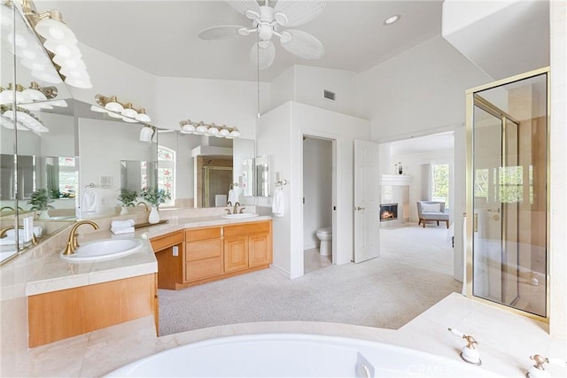 full bathroom with vanity, separate shower and tub, vaulted ceiling, ceiling fan, and toilet