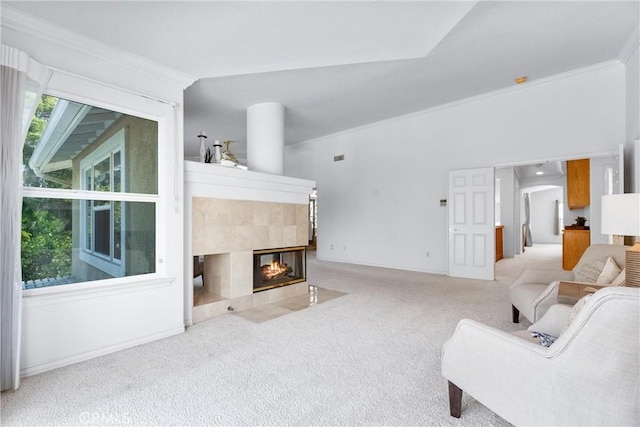 living room with carpet flooring, ornamental molding, and a tiled fireplace