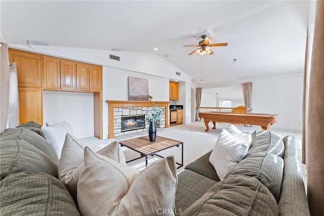 living room with light carpet, ceiling fan, billiards, a stone fireplace, and lofted ceiling