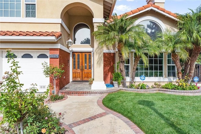 property entrance with a garage and a yard