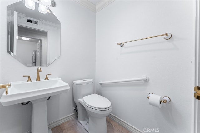 bathroom featuring toilet, sink, tile patterned flooring, and ornamental molding