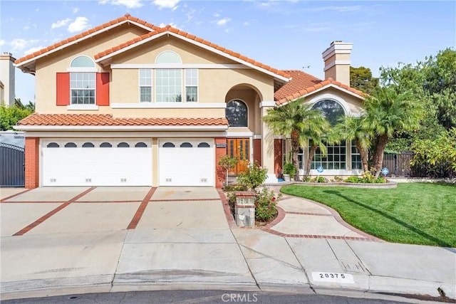 mediterranean / spanish home with a front lawn and a garage