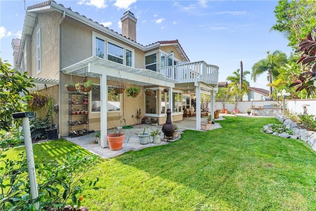 back of house with a pergola, a patio area, and a lawn