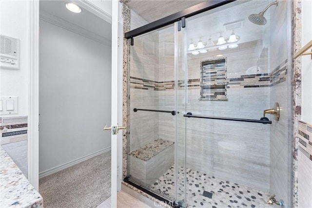 bathroom featuring a shower with door and crown molding