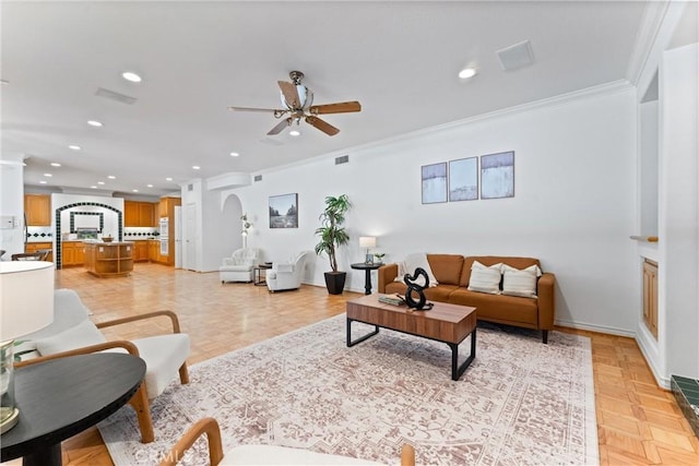 living room with ceiling fan, crown molding, and light parquet floors