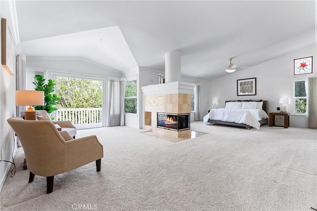 carpeted bedroom with ceiling fan, access to exterior, lofted ceiling, and a tile fireplace