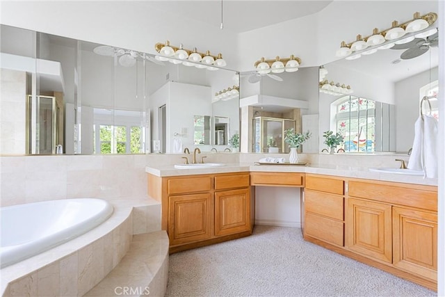 bathroom featuring independent shower and bath, ceiling fan, vanity, and a healthy amount of sunlight