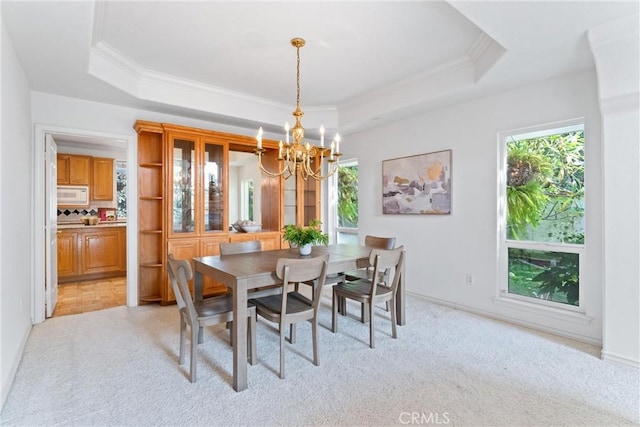 carpeted dining area featuring a notable chandelier and a raised ceiling