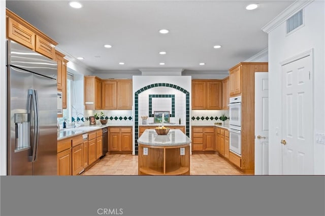 kitchen featuring a center island, double oven, backsplash, built in refrigerator, and ornamental molding