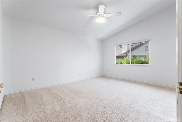 carpeted spare room featuring vaulted ceiling and ceiling fan