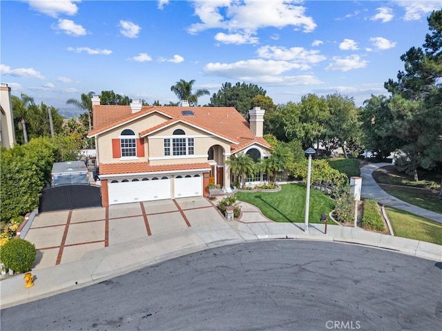 mediterranean / spanish home with a front lawn and a garage