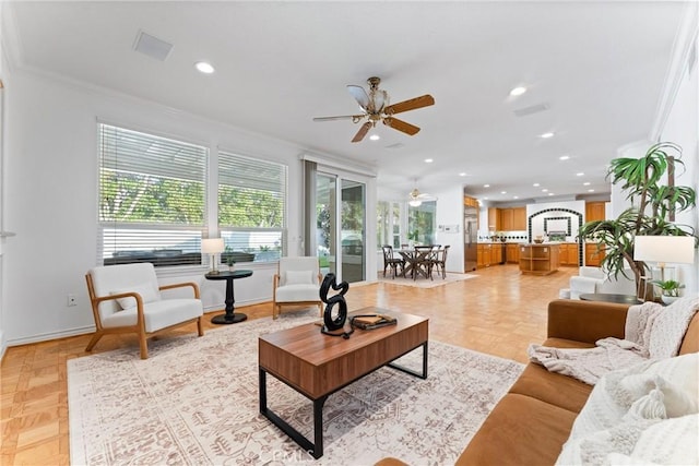 living room with light parquet floors, ceiling fan, and crown molding