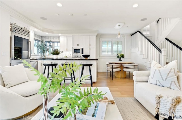 living room with crown molding and light hardwood / wood-style flooring