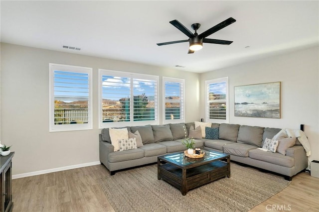 living room with light hardwood / wood-style flooring and ceiling fan