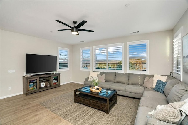 living room with light wood-type flooring and ceiling fan