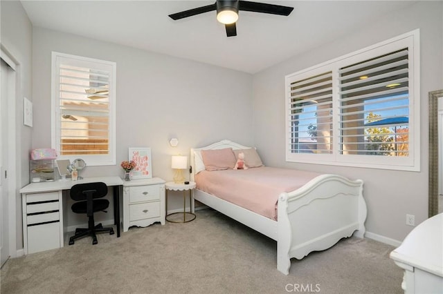 bedroom with light colored carpet, multiple windows, and ceiling fan